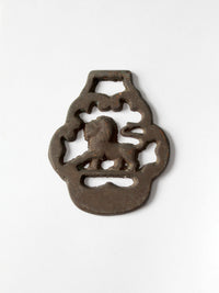 A brass horse harness ornament featuring a lion and a hanging loop, photographed on a clean white background.