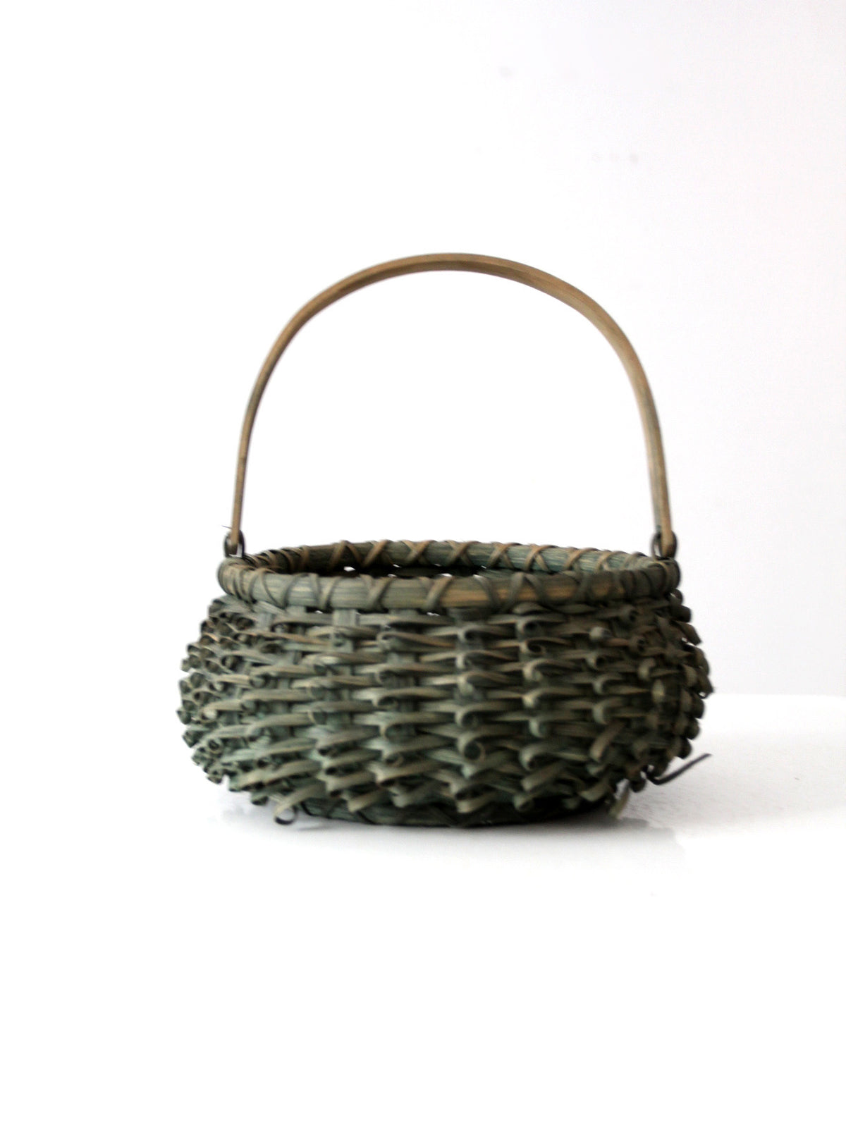 A small round green curl woven basket with a natural wood handle, shown on a plain white background.
