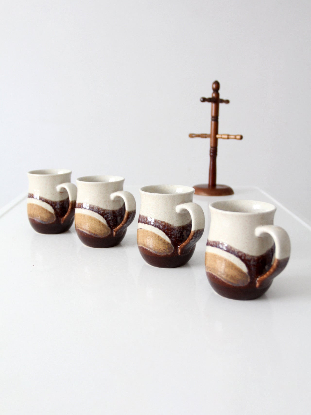 set of vintage handmade studio pottery mugs with wooden stand