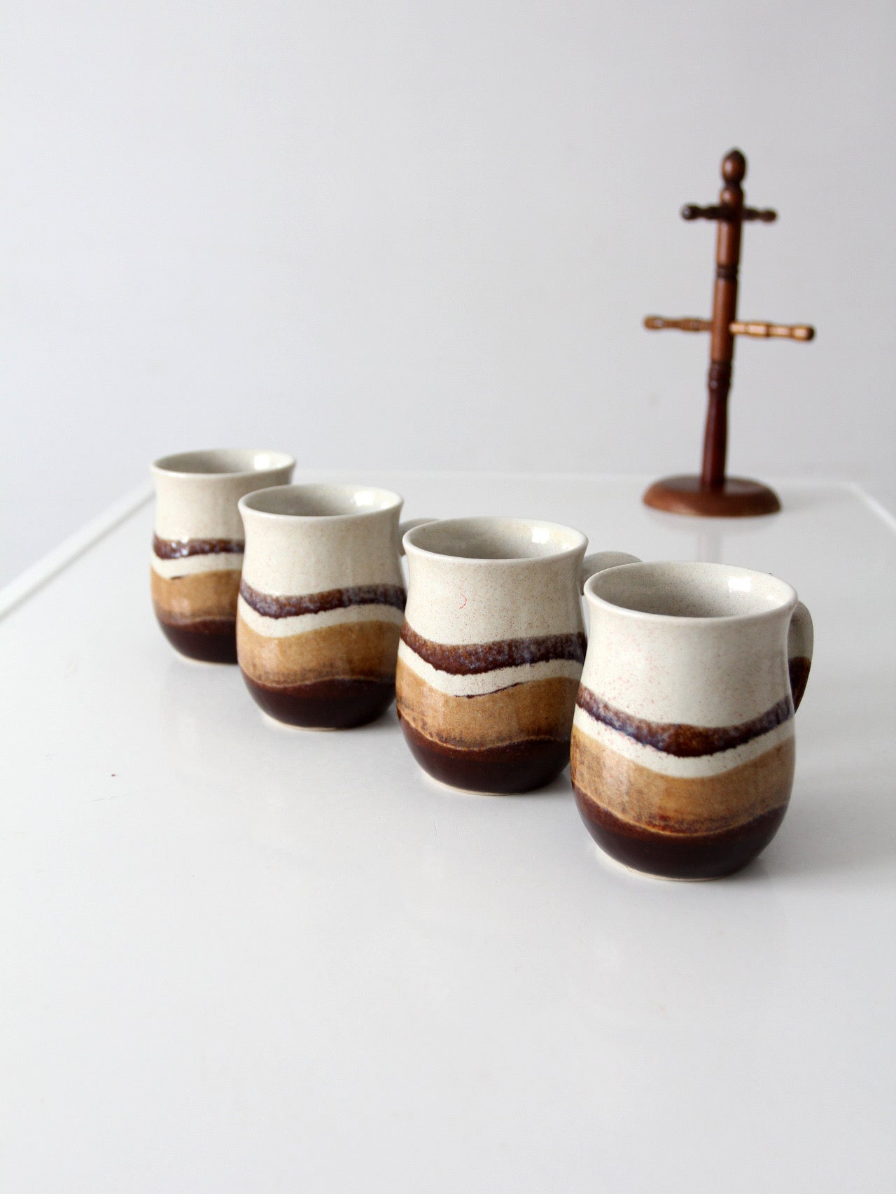 set of vintage handmade studio pottery mugs with wooden stand