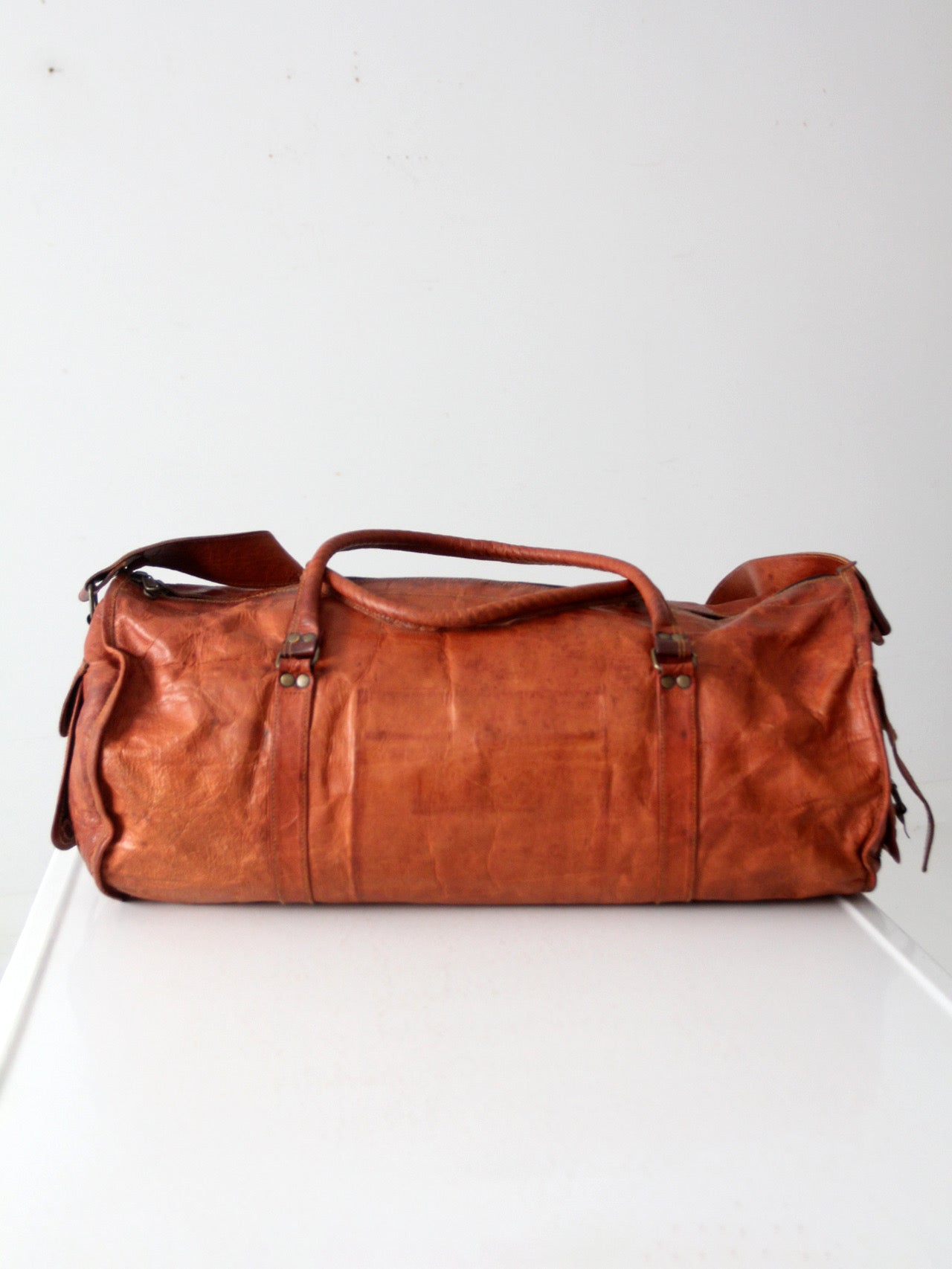 vintage brown leather duffle bag with shoulder strap