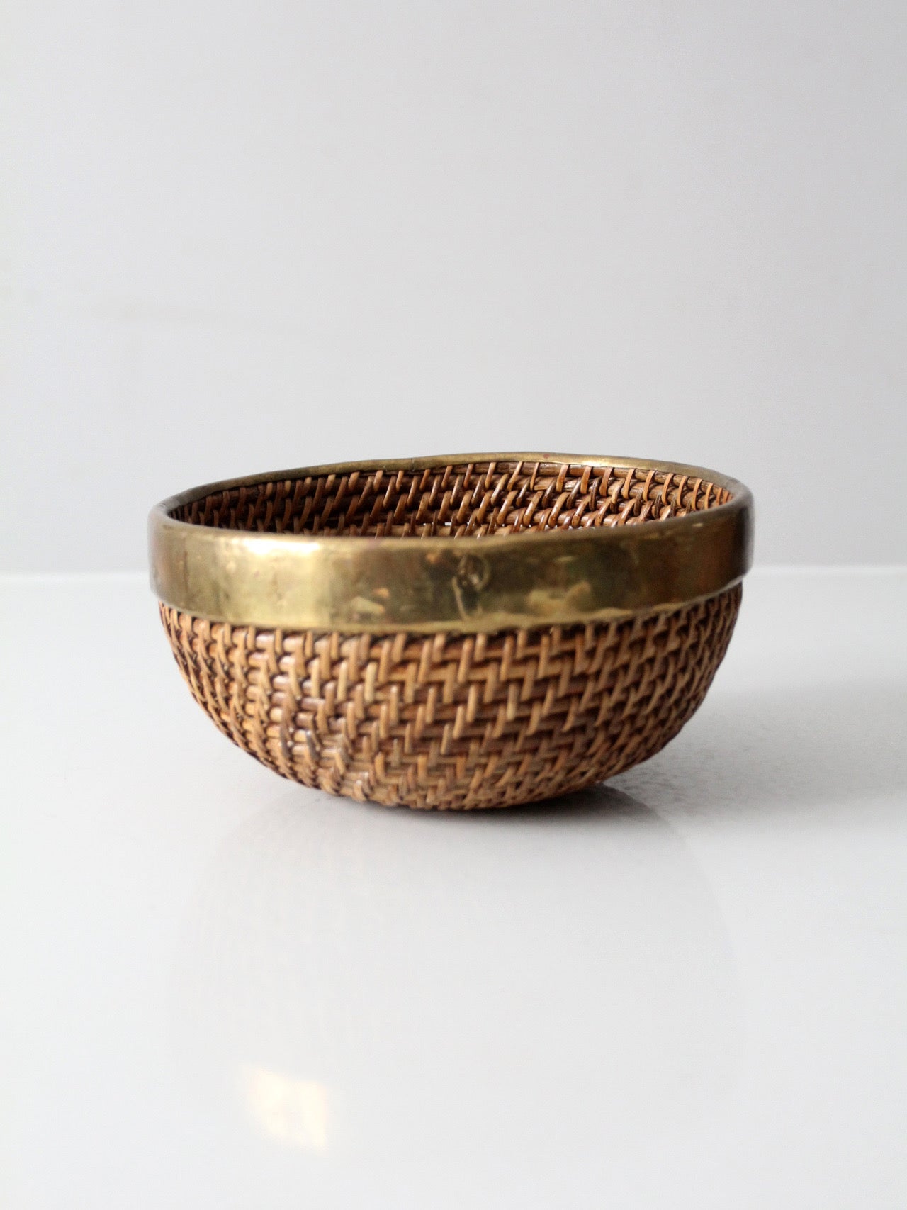 mid-century woven rattan bowl with brass rim