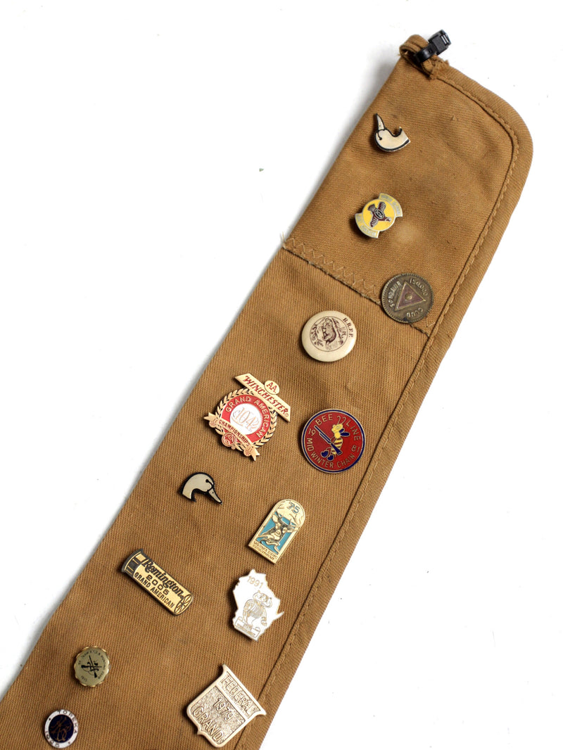 vintage gun club pin collection on Blue Bill canvas rifle case