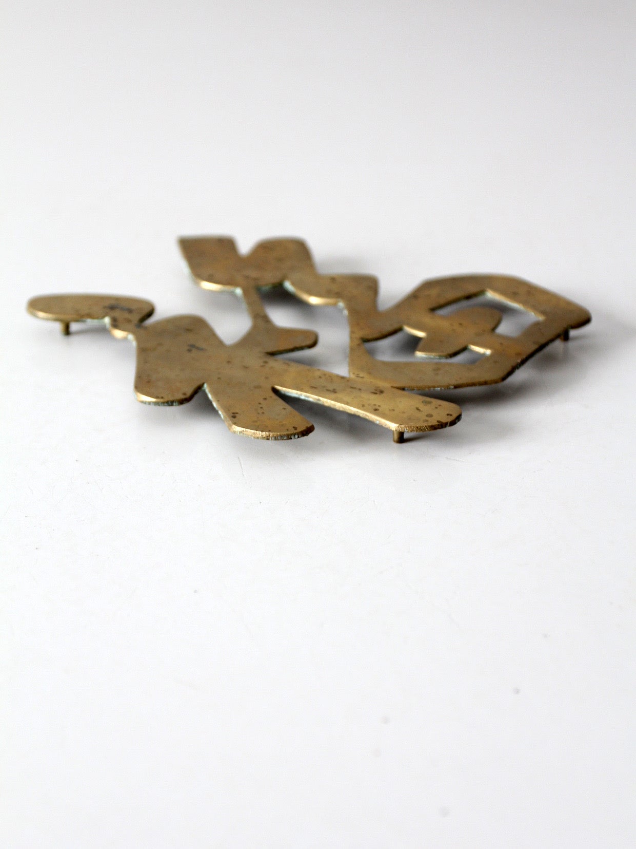 vintage brass good luck symbol trivet
