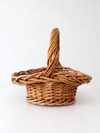 vintage woven wicker gathering basket with twisted handle