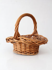 vintage woven wicker gathering basket with twisted handle