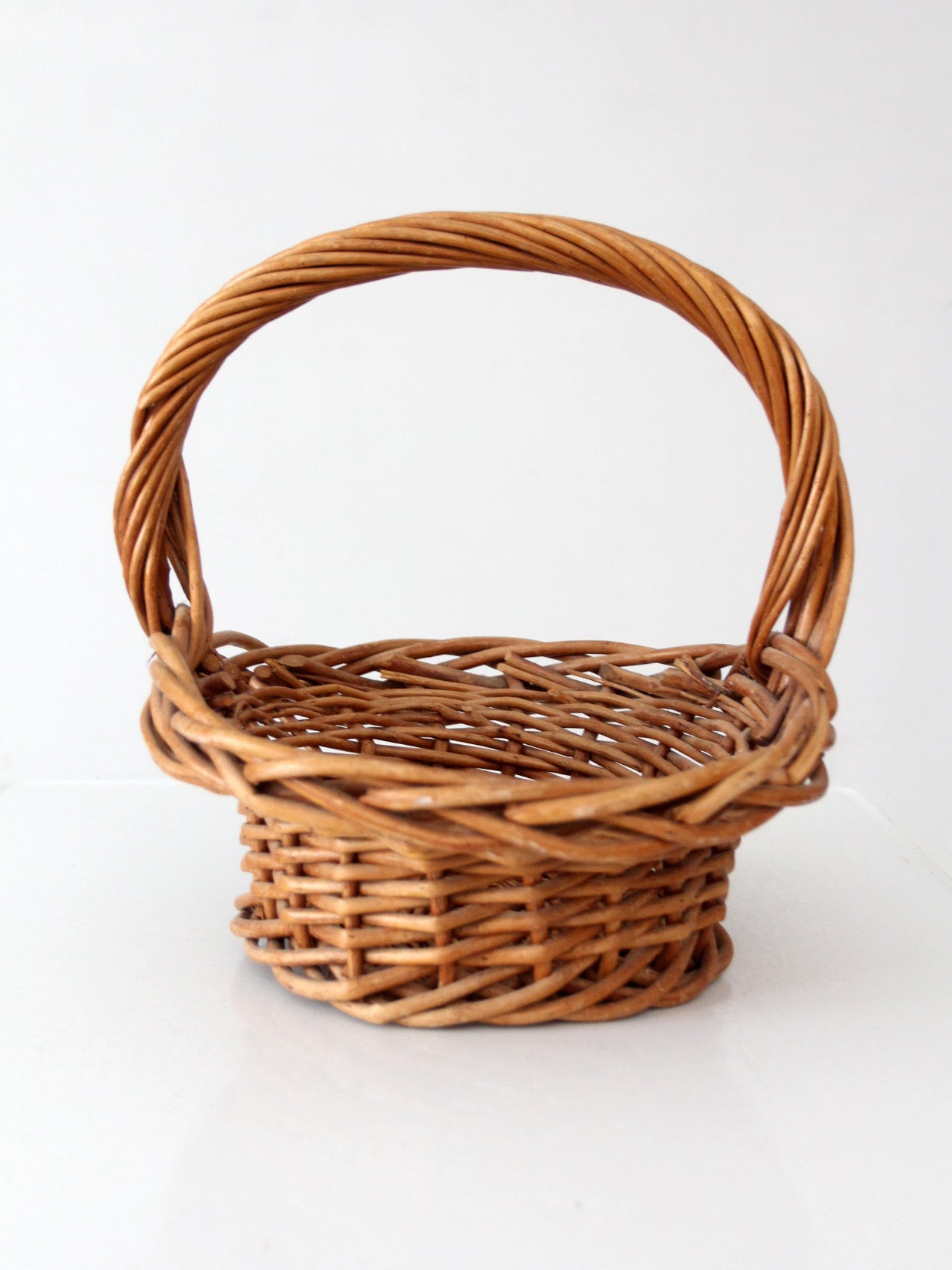 vintage woven wicker gathering basket with twisted handle