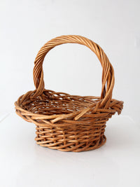 vintage woven wicker gathering basket with twisted handle