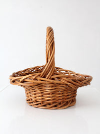 vintage woven wicker gathering basket with twisted handle