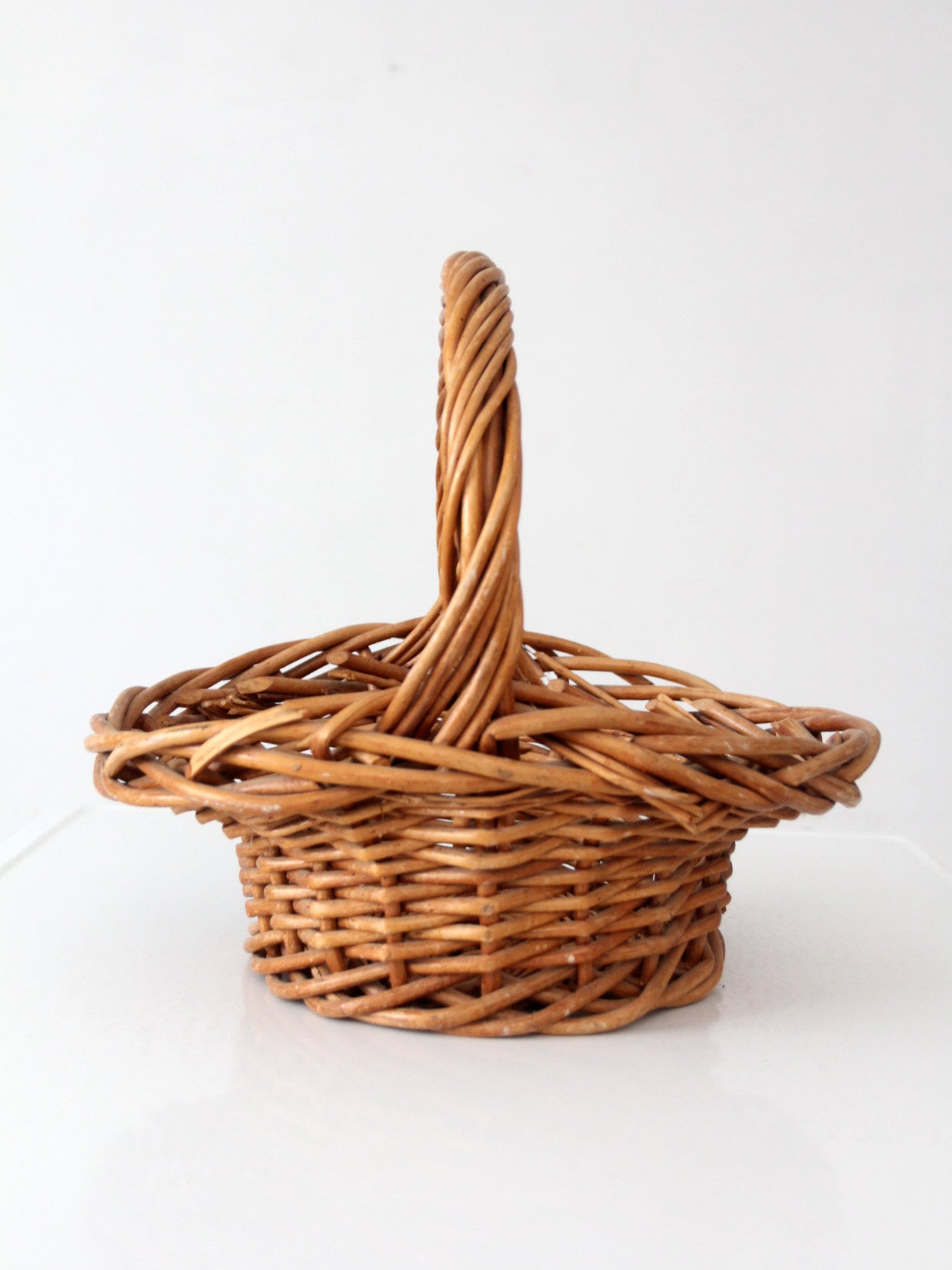 vintage woven wicker gathering basket with twisted handle