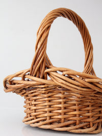 vintage woven wicker gathering basket with twisted handle