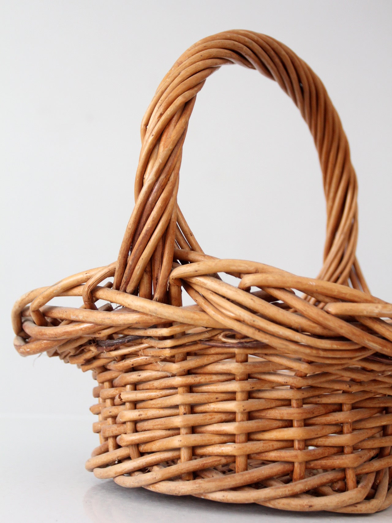 vintage woven wicker gathering basket with twisted handle