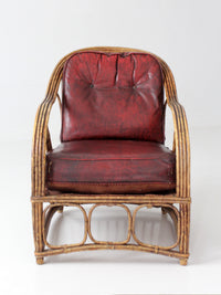 antique rattan lounge chair with oxblood cushions