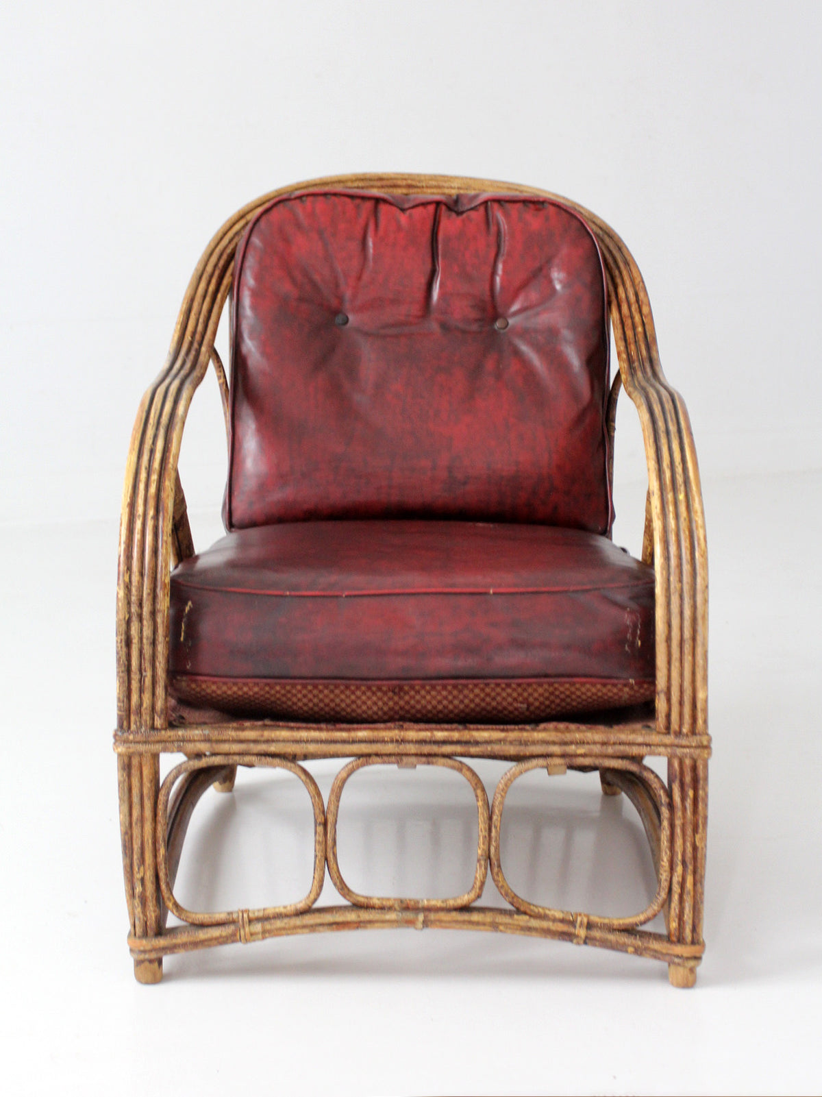 antique rattan lounge chair with oxblood cushions