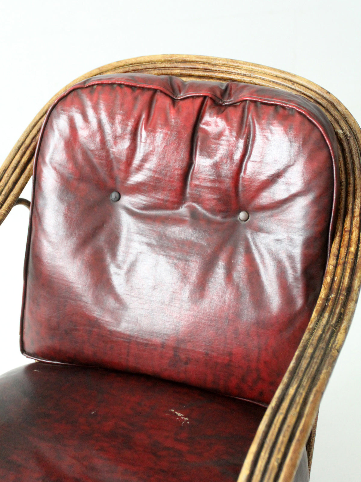 antique rattan lounge chair with oxblood cushions