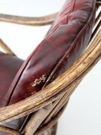 antique rattan lounge chair with oxblood cushions