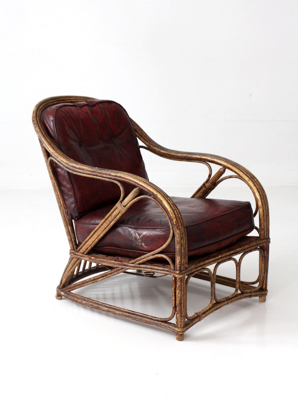 antique rattan lounge chair with oxblood cushions