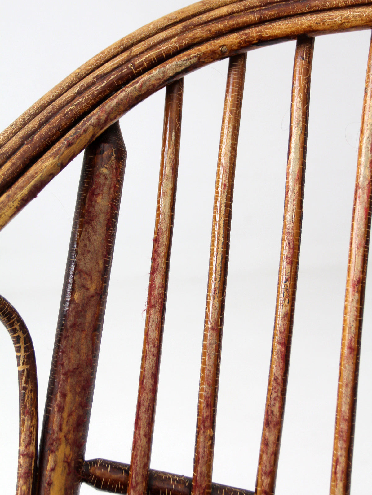 antique rattan lounge chair with oxblood cushions