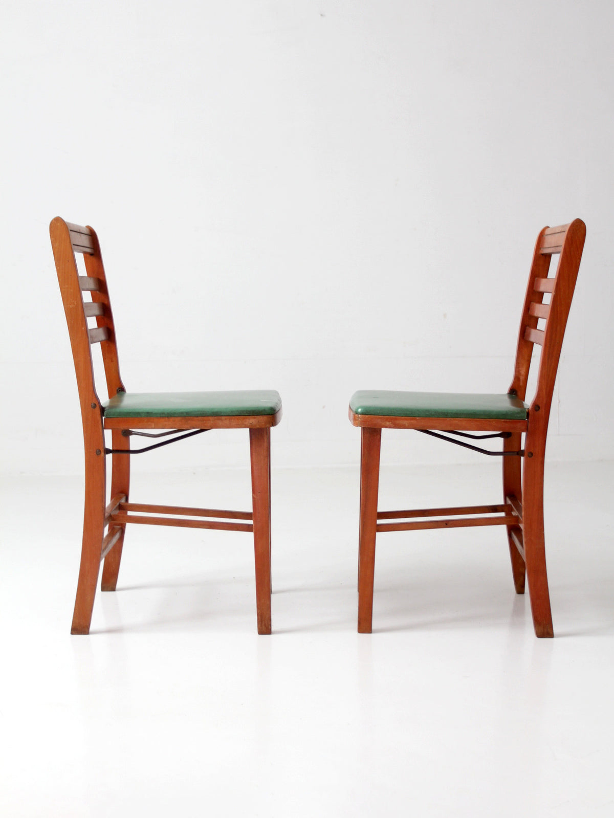 pair of 1950s wooden folding chairs with green seats