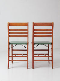 pair of 1950s wooden folding chairs with green seats
