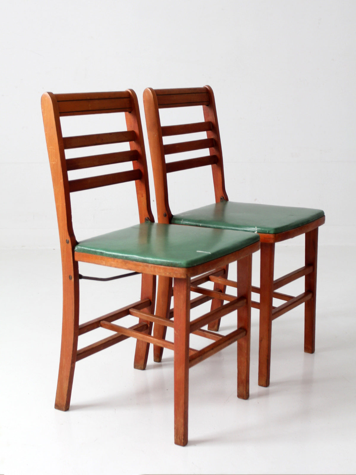 pair of 1950s wooden folding chairs with green seats