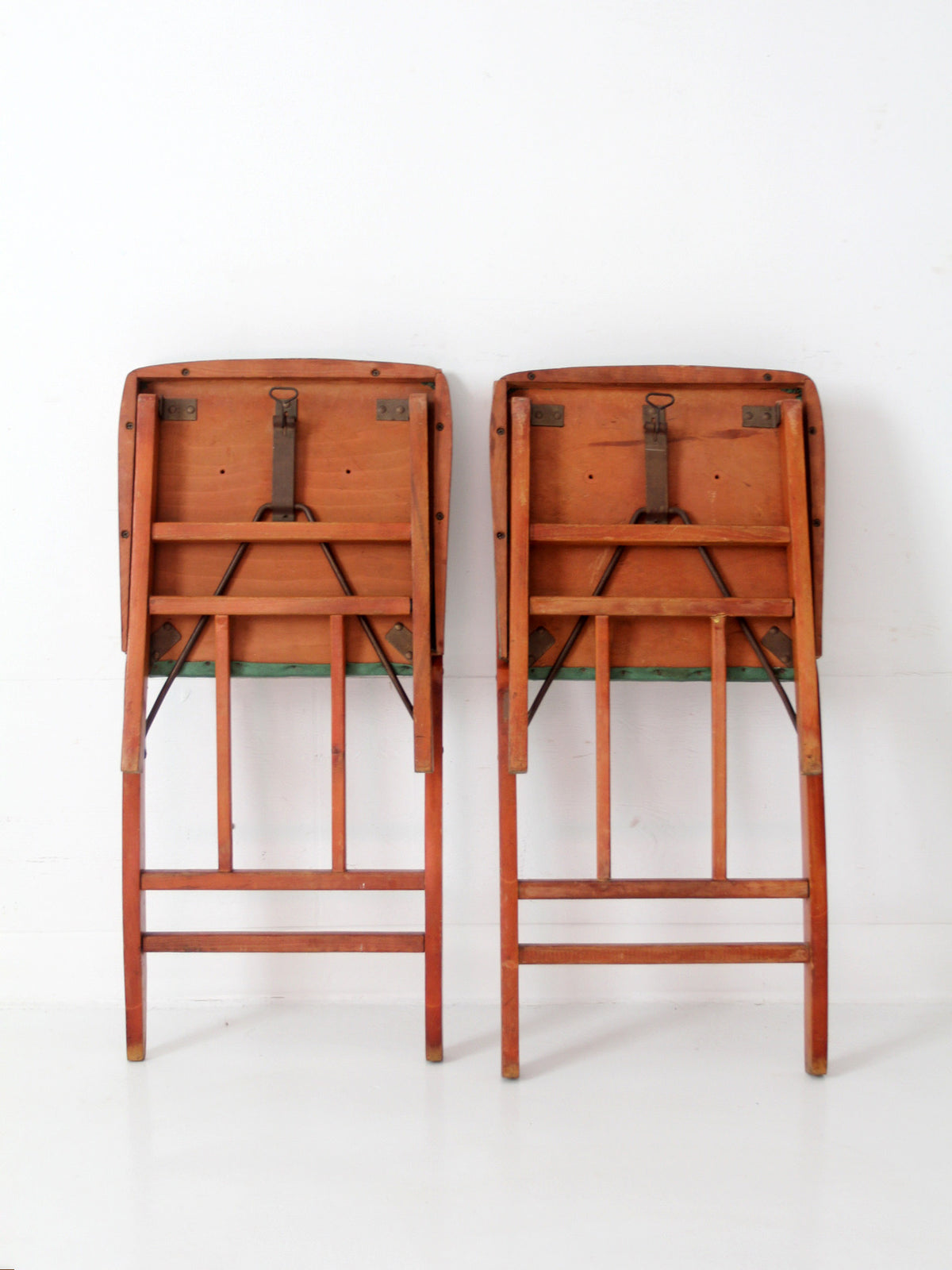 pair of 1950s wooden folding chairs with green seats