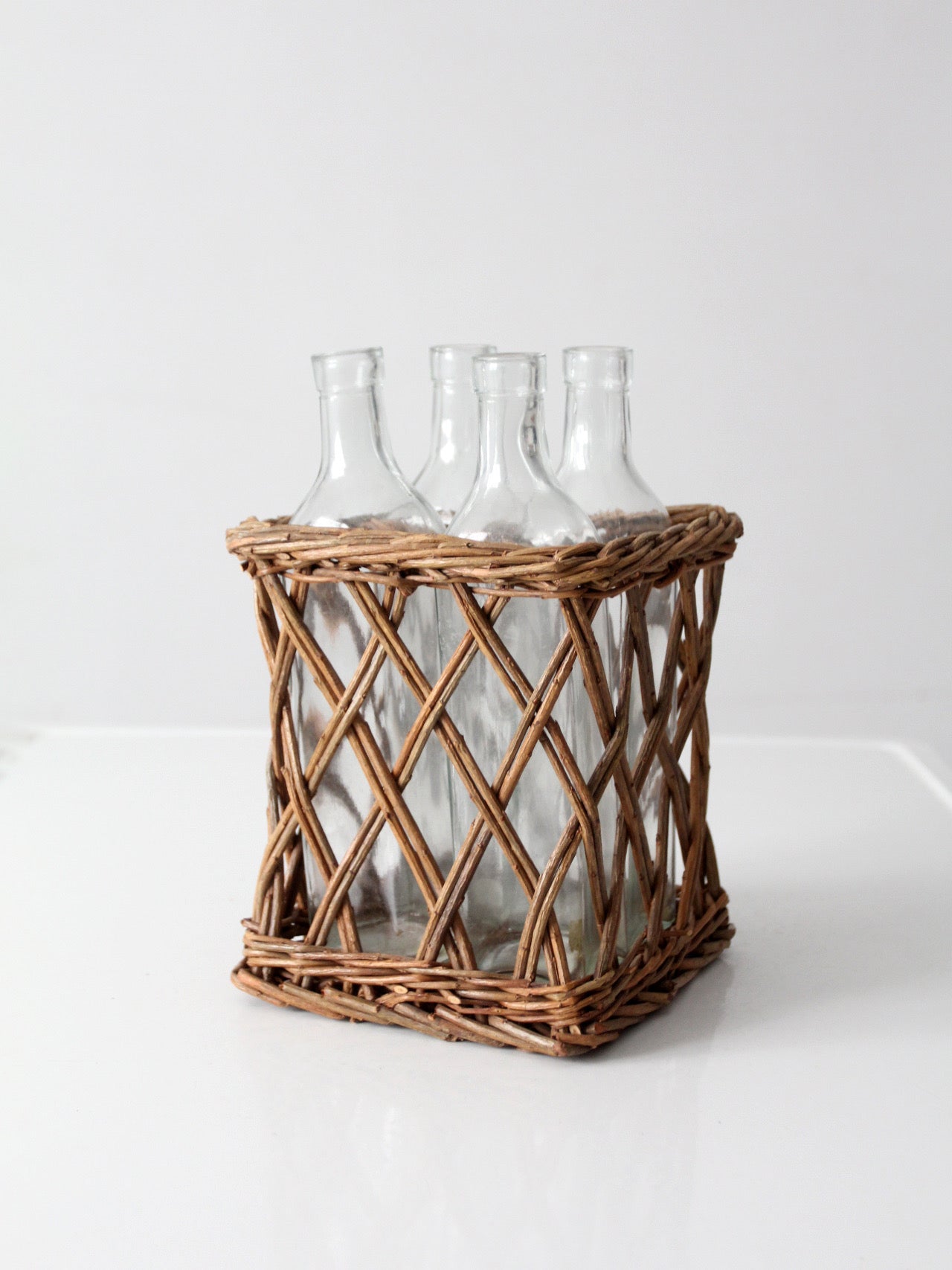 vintage wicker bottle basket with glass bottles