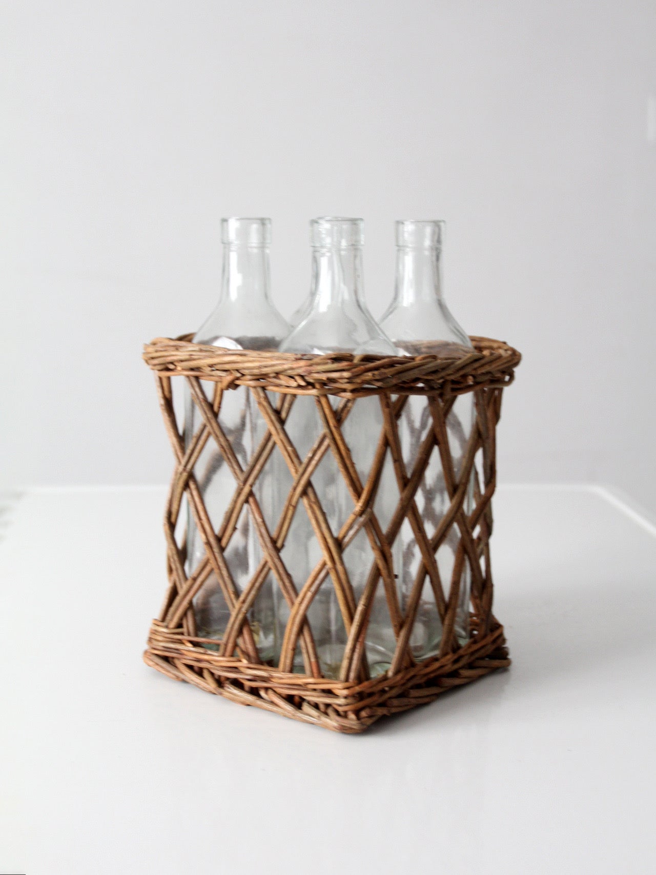 vintage wicker bottle basket with glass bottles