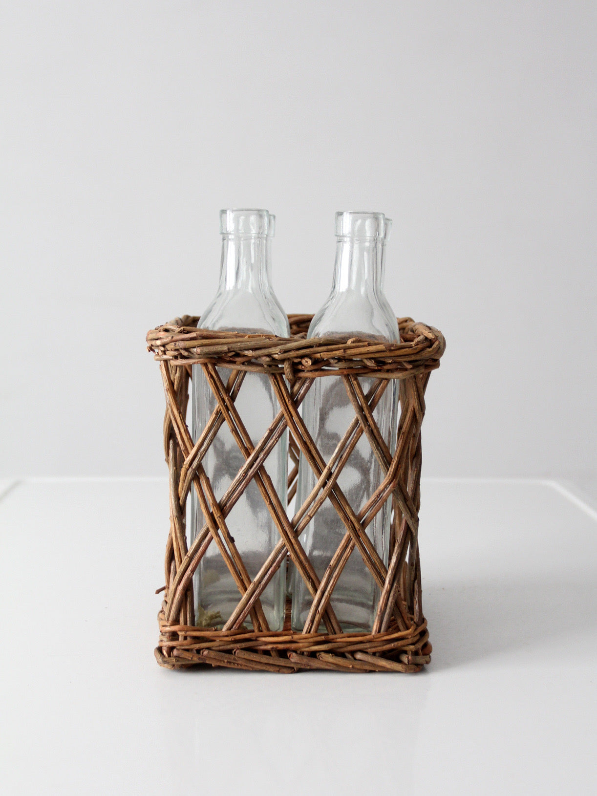 vintage wicker bottle basket with glass bottles