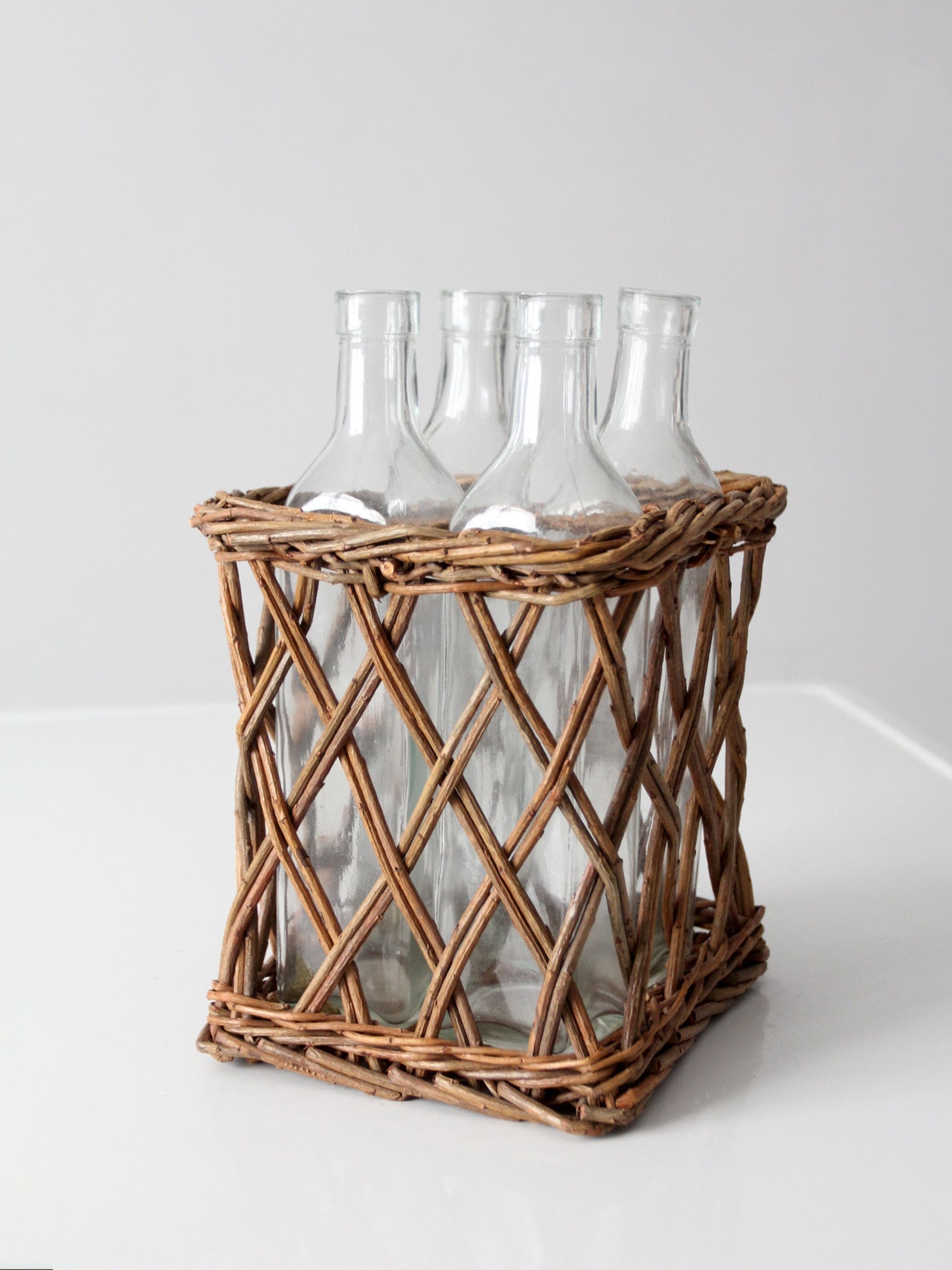 vintage wicker bottle basket with glass bottles