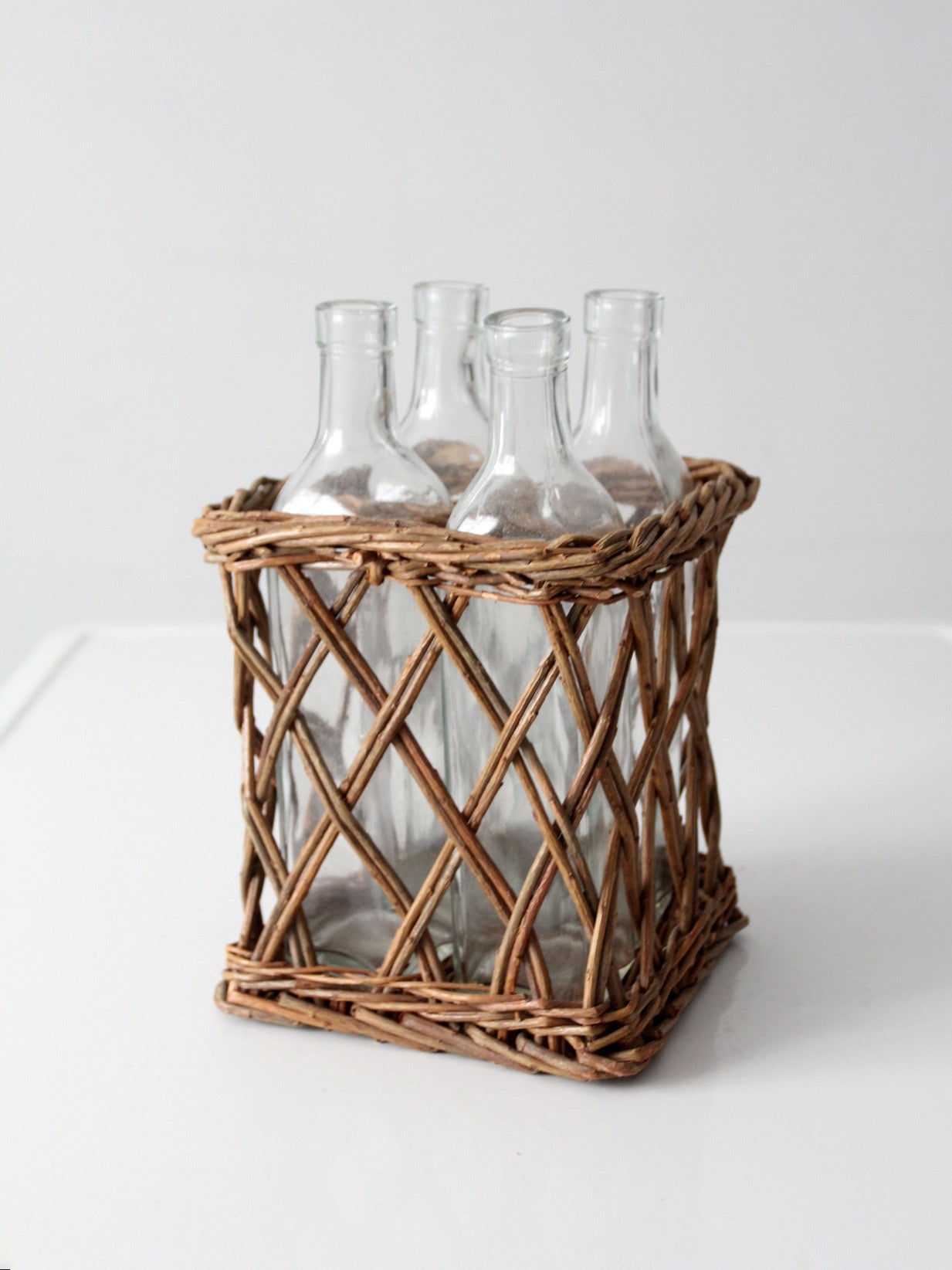 vintage wicker bottle basket with glass bottles