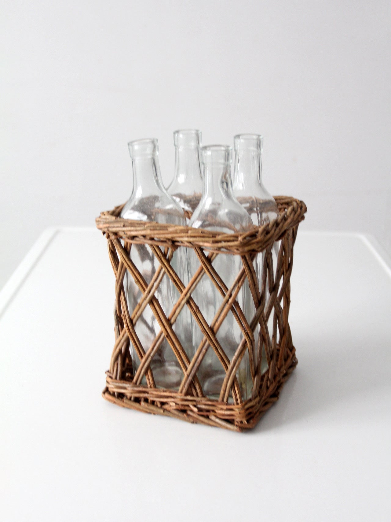 vintage wicker bottle basket with glass bottles
