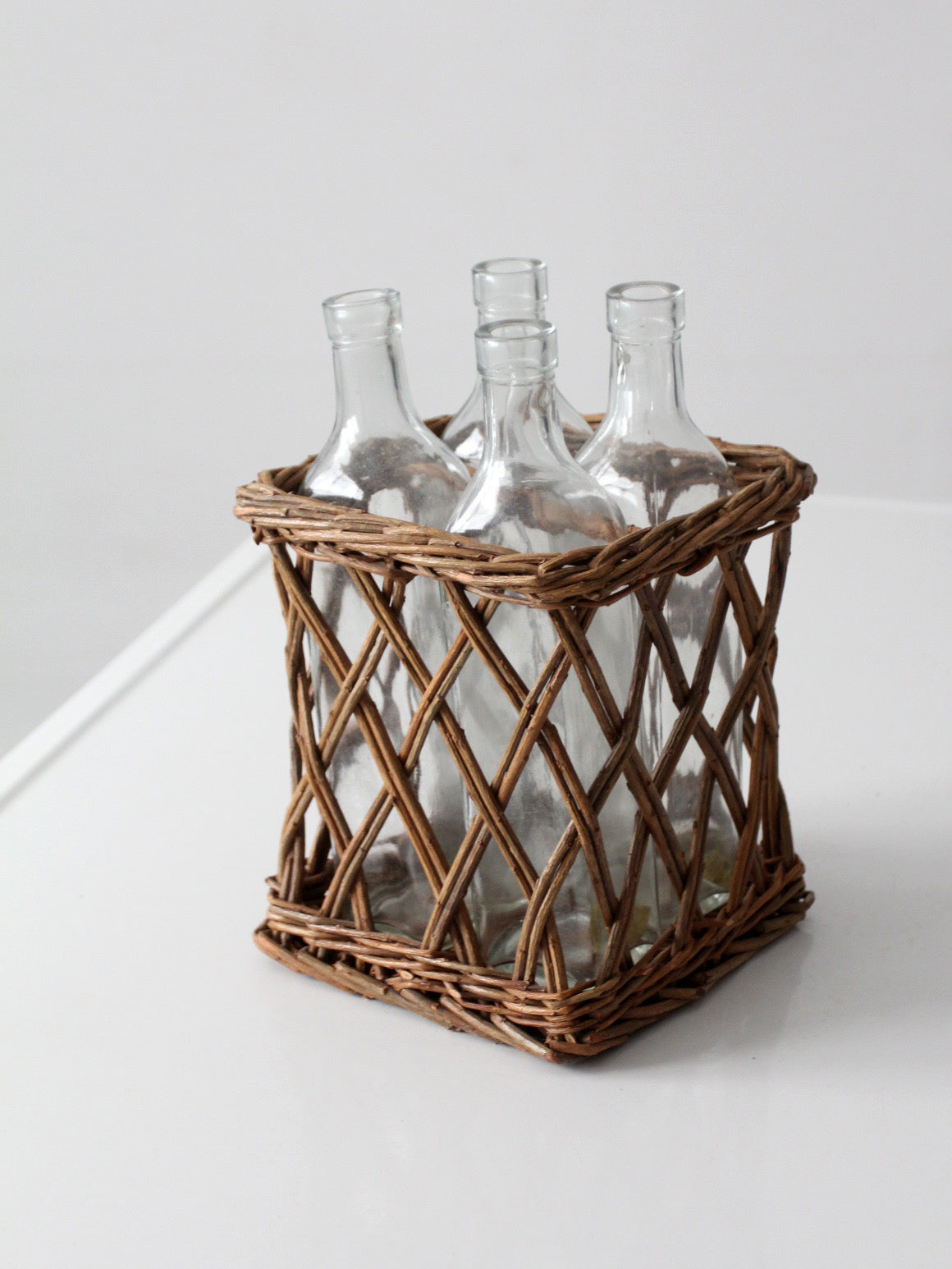 vintage wicker bottle basket with glass bottles