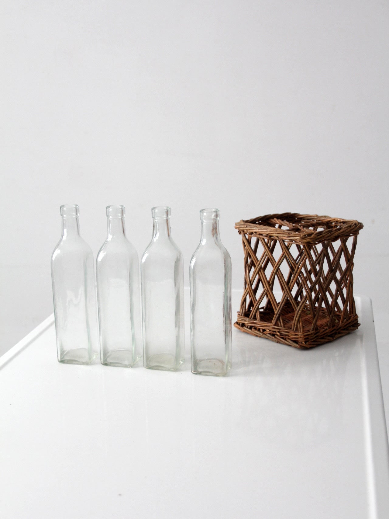 vintage wicker bottle basket with glass bottles