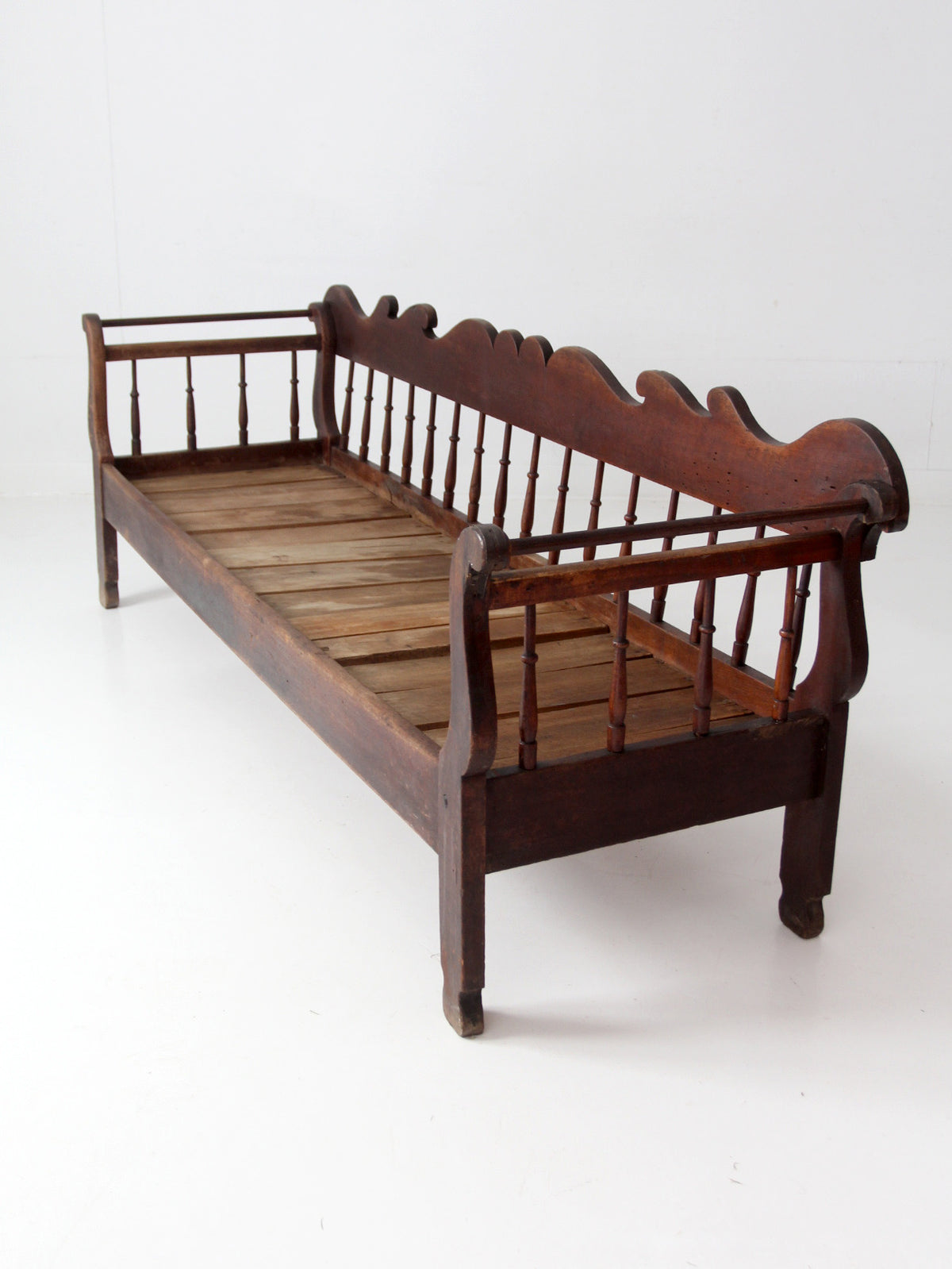 antique 19th century wooden spindle back bench with scalloped crest rail