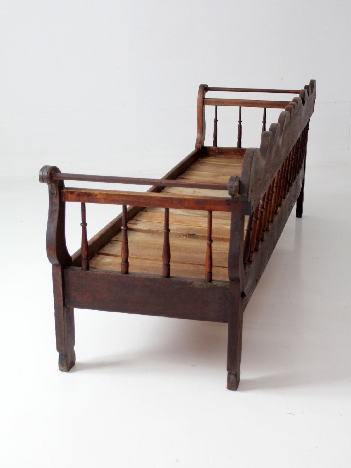 antique 19th century wooden spindle back bench with scalloped crest rail
