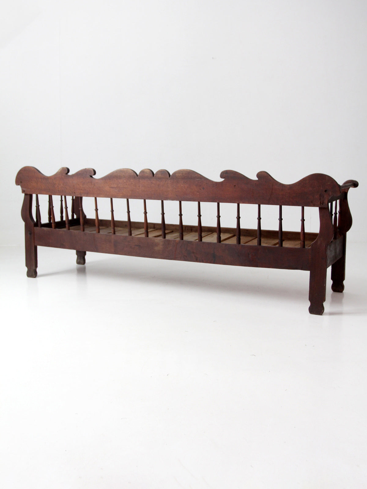 antique 19th century wooden spindle back bench with scalloped crest rail