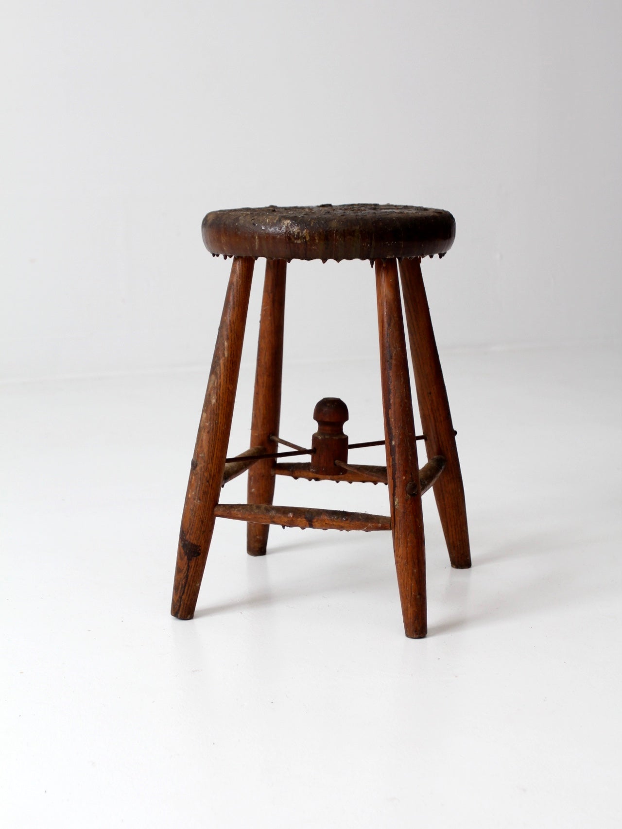 antique wooden stool with wire stretcher