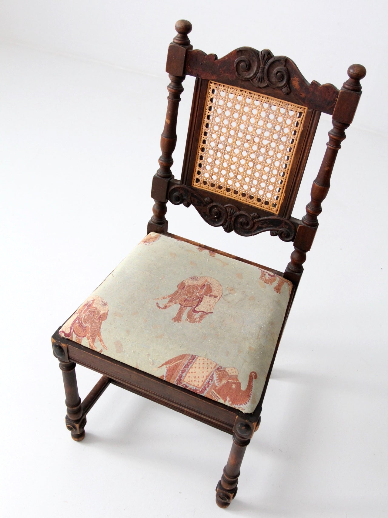 carved wood chair with cane back